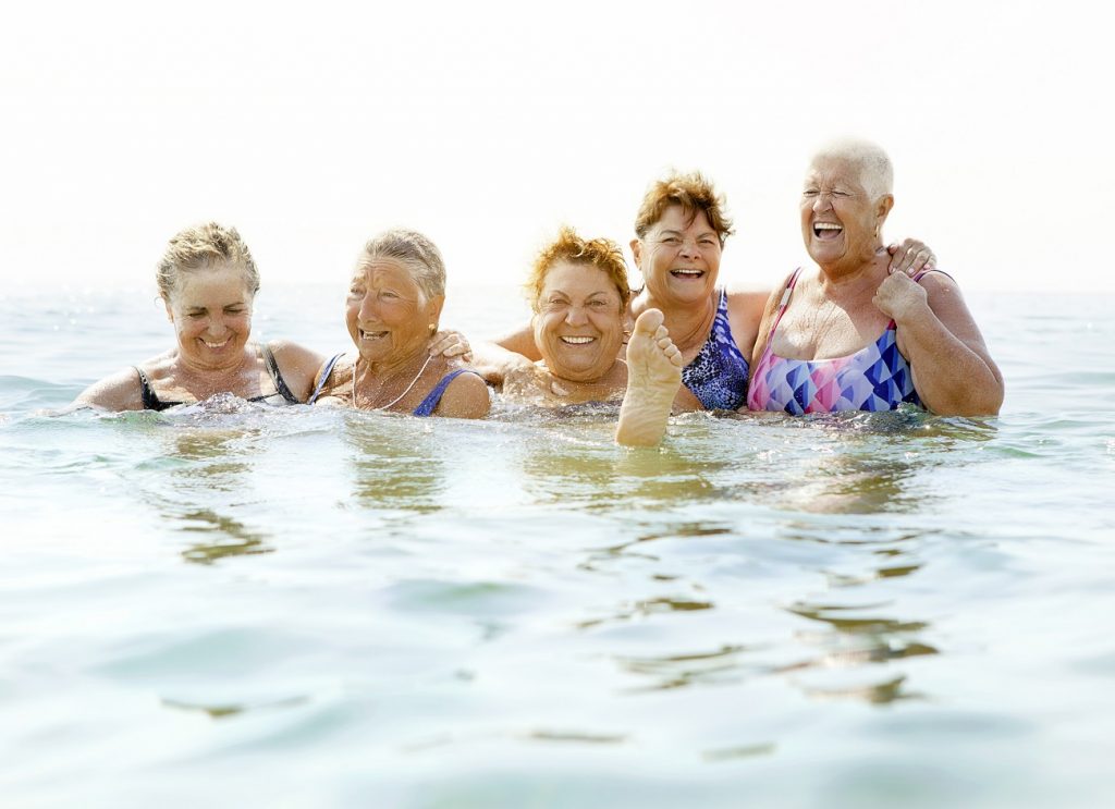 Mature ladies laughing on beach